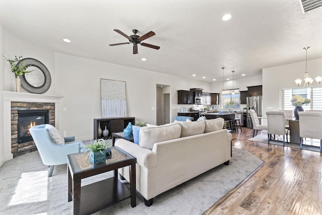 18277 N Streams Edge Way, Boise, ID 83714 - living room featuring ceiling fan, a stone fireplace, a chandelier, recessed lighting, and wood finished floors
