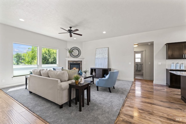 18277 N Streams Edge Way, Boise, ID 83714 - living area with recessed lighting, a ceiling fan, wood finished floors, a stone fireplace, and baseboards
