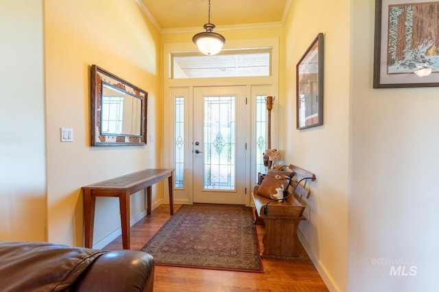 foyer entrance with ornamental molding and light hardwood / wood-style floors