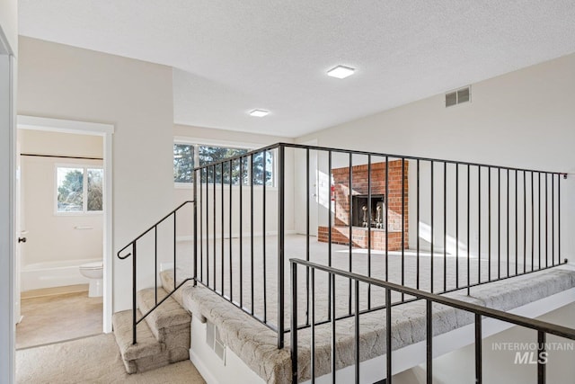 stairs with a textured ceiling and carpet floors