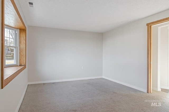 spare room with carpet floors and a textured ceiling