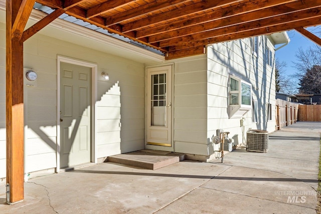 view of exterior entry featuring a patio area and cooling unit