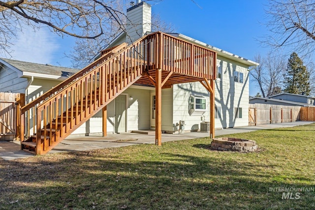 back of property featuring an outdoor fire pit, a patio area, a lawn, and a wooden deck