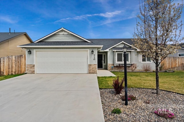 view of front of home featuring stone siding, driveway, an attached garage, and a front yard