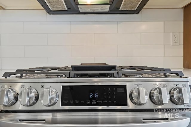 details featuring gas stove, decorative backsplash, and exhaust hood