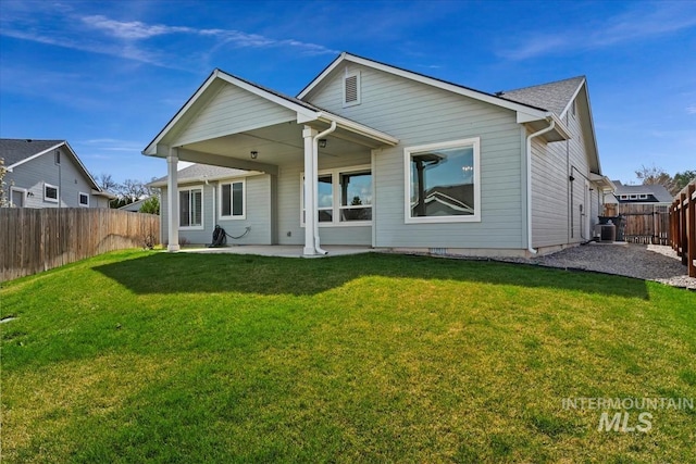 back of house with a fenced backyard, a patio area, and a lawn