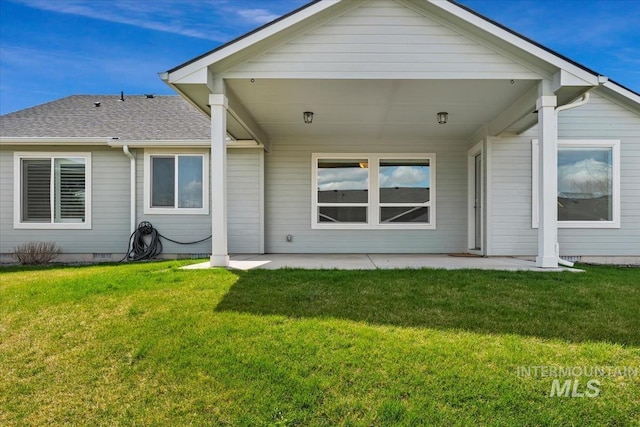 rear view of house with a patio, a shingled roof, crawl space, and a yard