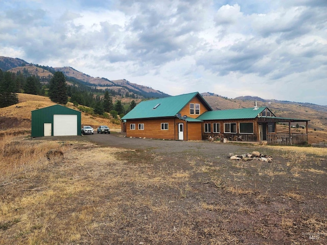 view of front facade with a garage, a mountain view, and an outbuilding