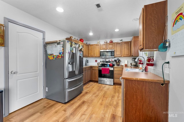 1056 S Hebgon Lake Ave, Middleton, ID 83644 - kitchen featuring appliances with stainless steel finishes, brown cabinets, light wood-type flooring, and recessed lighting