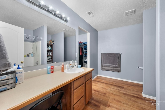 1056 S Hebgon Lake Ave, Middleton, ID 83644 - bathroom featuring vanity, wood finished floors, a shower, a spacious closet, and a textured ceiling