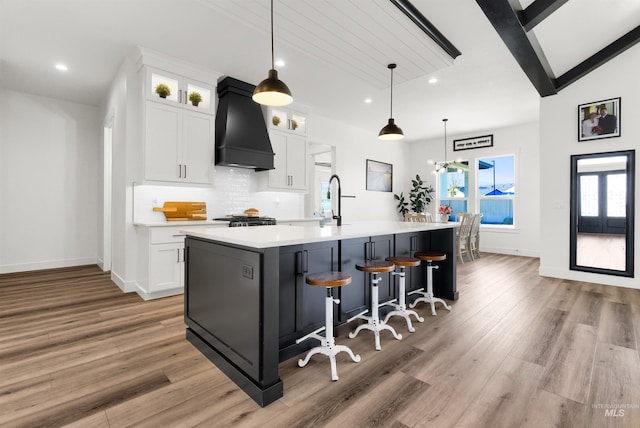 11127 Lake Lowell Ave, Nampa, ID 83686 - kitchen with custom range hood, light wood finished floors, recessed lighting, light countertops, and a center island with sink