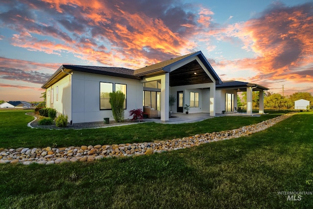 11127 Lake Lowell Ave, Nampa, ID 83686 - back of property at dusk with a lawn and a patio area
