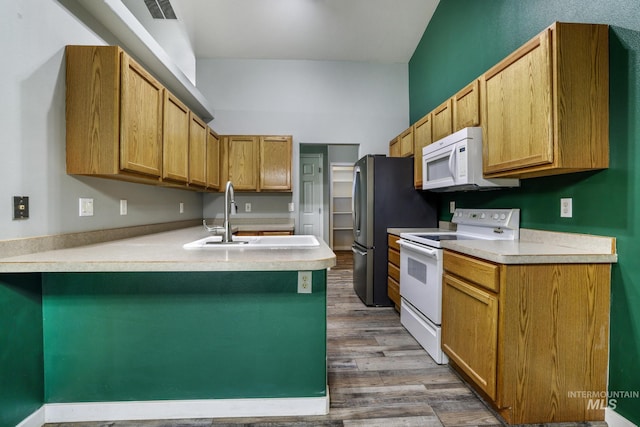 224 Paintbrush Cir, Twin Falls, ID 83301 - kitchen with white appliances, a sink, a peninsula, dark wood-style flooring, and light countertops