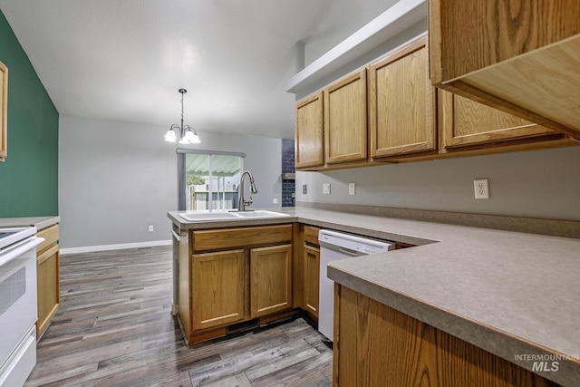 224 Paintbrush Cir, Twin Falls, ID 83301 - kitchen featuring a sink, white appliances, a peninsula, light wood-style flooring, and a chandelier