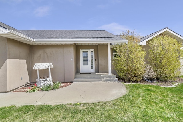 224 Paintbrush Cir, Twin Falls, ID 83301 - view of exterior entry with roof with shingles, stucco siding, and a yard