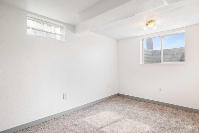 unfurnished room featuring carpet and baseboards