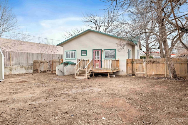 back of property with a deck and a fenced backyard