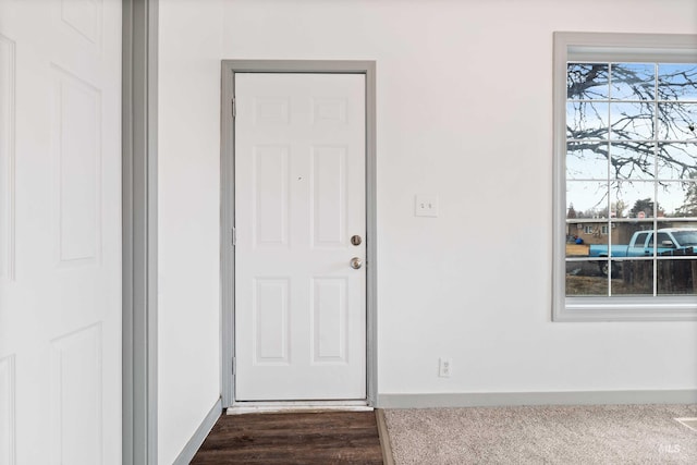 doorway to outside with dark wood finished floors and baseboards