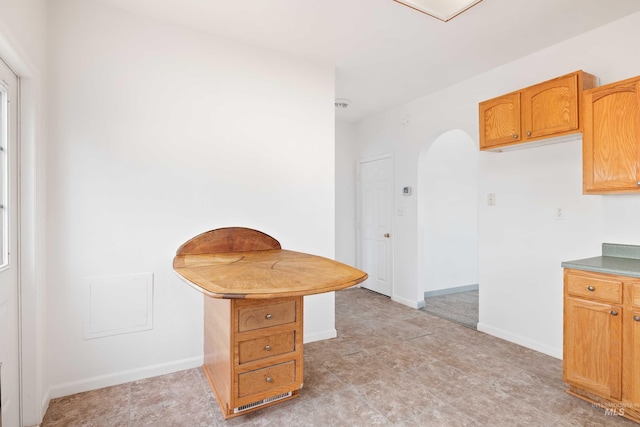 kitchen with arched walkways and baseboards