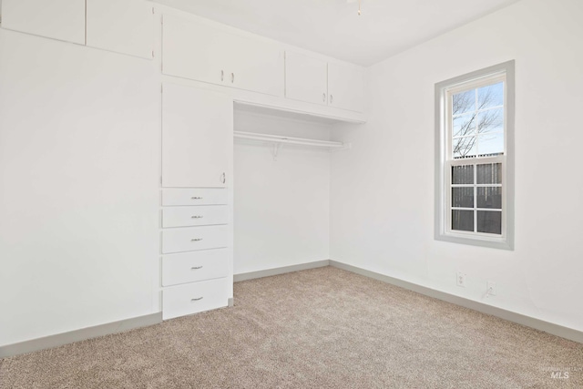 unfurnished bedroom featuring carpet floors, baseboards, and a closet