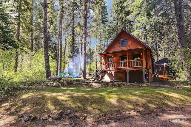 1221 Fox Rd, Cascade, ID 83611 - view of front of house featuring stairs, a porch, log siding, and a view of trees