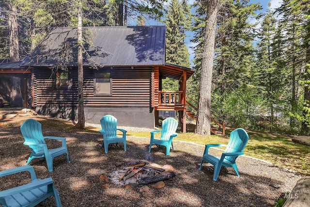 1221 Fox Rd, Cascade, ID 83611 - rear view of house with log siding, metal roof, and a fire pit