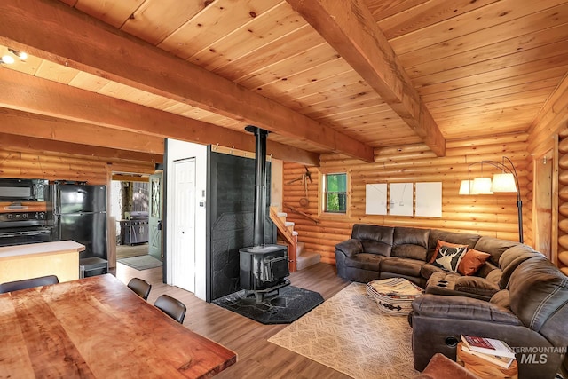 1221 Fox Rd, Cascade, ID 83611 - living area featuring a wood stove, wood finished floors, wood ceiling with exposed beams, and log walls