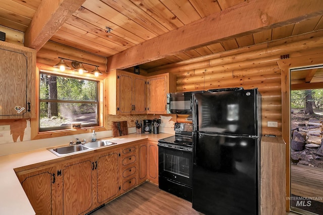 1221 Fox Rd, Cascade, ID 83611 - kitchen with black appliances, rustic walls, a sink, wooden ceiling with exposed beams, and light wood-type flooring