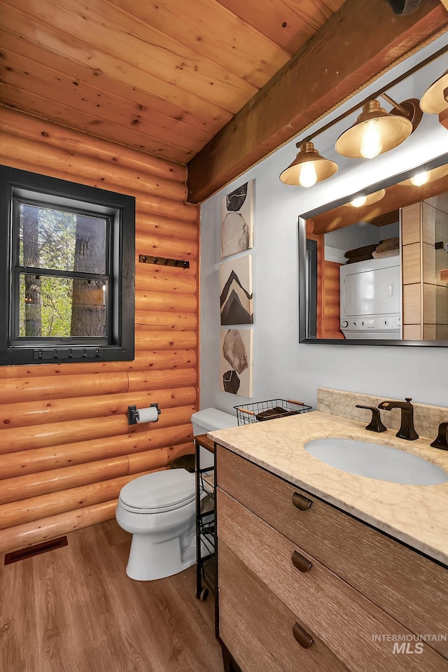 1221 Fox Rd, Cascade, ID 83611 - bathroom with wood finished floors, toilet, vanity, rustic walls, and wooden ceiling