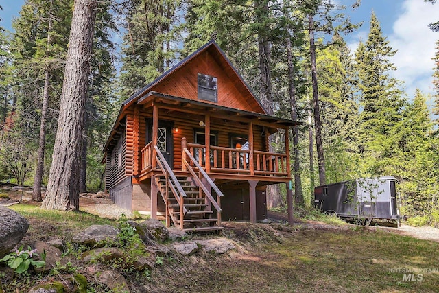 1221 Fox Rd, Cascade, ID 83611 - log cabin featuring stairs, log exterior, and a view of trees
