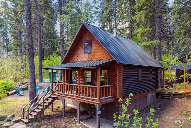 1221 Fox Rd, Cascade, ID 83611 - view of front of house with log siding, metal roof, a porch, stairway, and a wooden deck