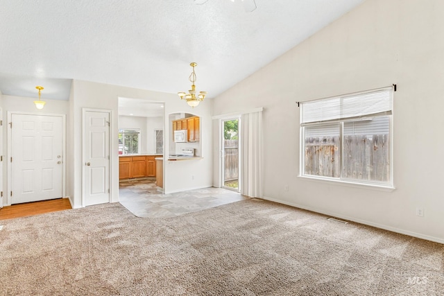 3000 E Ohio Ave, Nampa, ID 83686 - unfurnished living room with light colored carpet, a chandelier, lofted ceiling, and baseboards