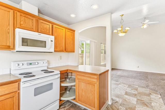 3000 E Ohio Ave, Nampa, ID 83686 - kitchen featuring white appliances, a peninsula, light countertops, light colored carpet, and arched walkways
