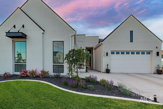 ranch-style home featuring driveway, stucco siding, and a front lawn