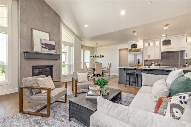 living room featuring a fireplace, light hardwood / wood-style flooring, and vaulted ceiling