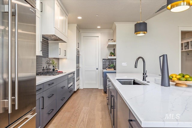 kitchen featuring pendant lighting, white cabinets, sink, gray cabinets, and appliances with stainless steel finishes