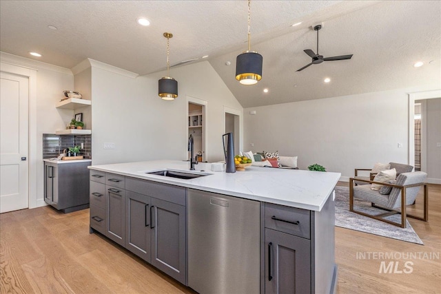 kitchen with gray cabinetry, sink, stainless steel dishwasher, pendant lighting, and a center island with sink