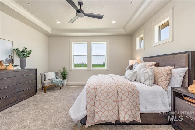 carpeted bedroom featuring ceiling fan, a raised ceiling, and a textured ceiling