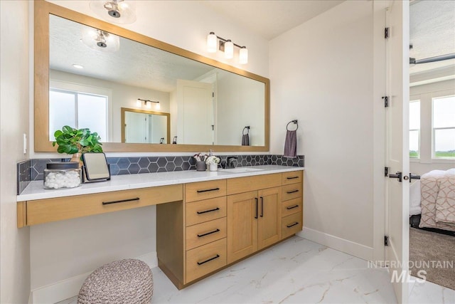 bathroom featuring tasteful backsplash, a wealth of natural light, vanity, and a textured ceiling