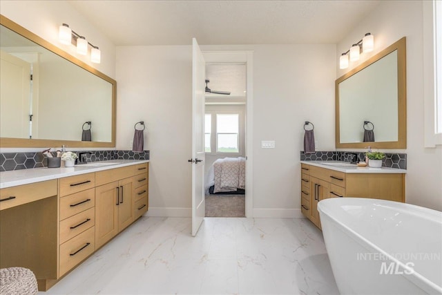 bathroom with a bathing tub, vanity, and backsplash