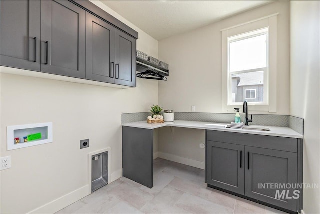 washroom with washer hookup, electric dryer hookup, cabinets, and sink