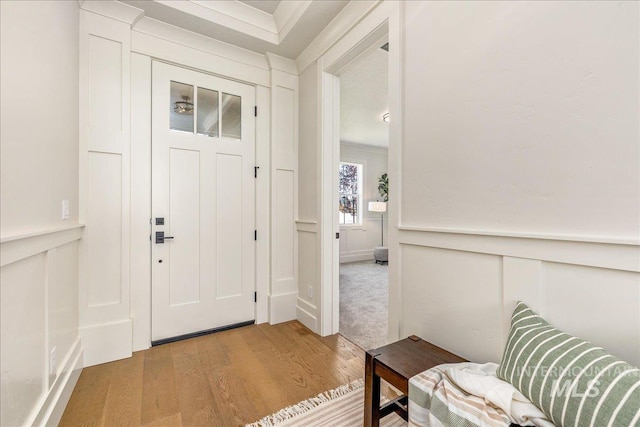 foyer with light hardwood / wood-style floors and ornamental molding