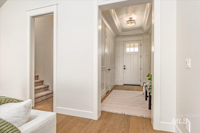 foyer with a raised ceiling and light hardwood / wood-style floors