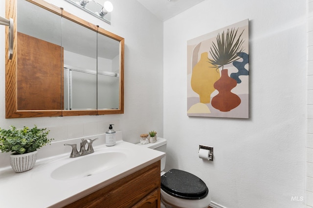 full bathroom featuring an enclosed shower, toilet, and vanity