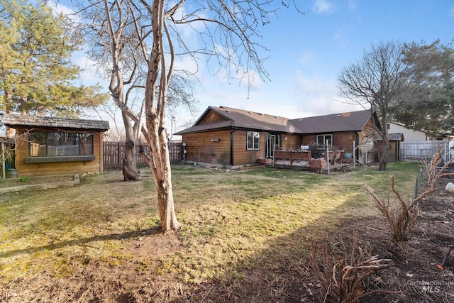 back of house featuring a lawn and a fenced backyard