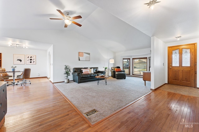 living area featuring visible vents, ceiling fan, baseboards, light wood-style floors, and high vaulted ceiling