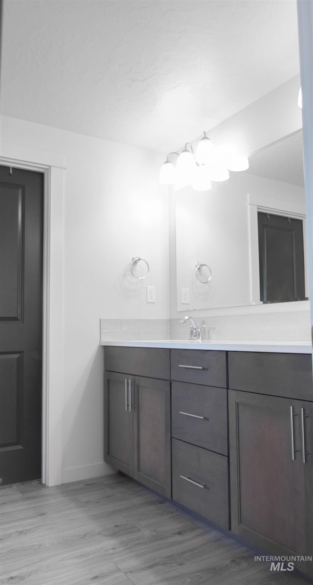 bathroom featuring baseboards, wood finished floors, and vanity