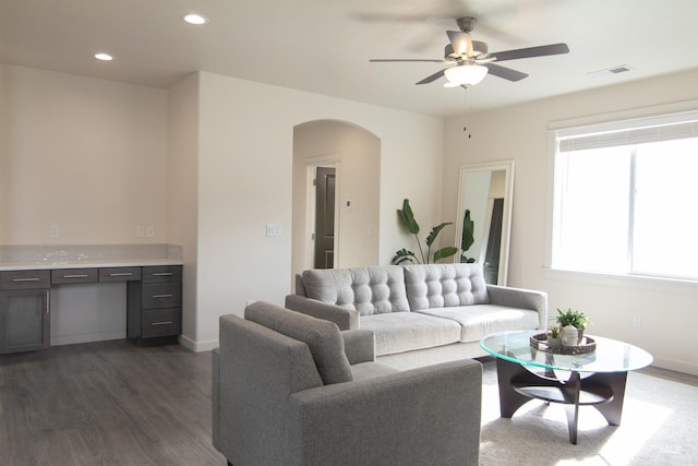 living room featuring visible vents, arched walkways, dark wood finished floors, baseboards, and recessed lighting