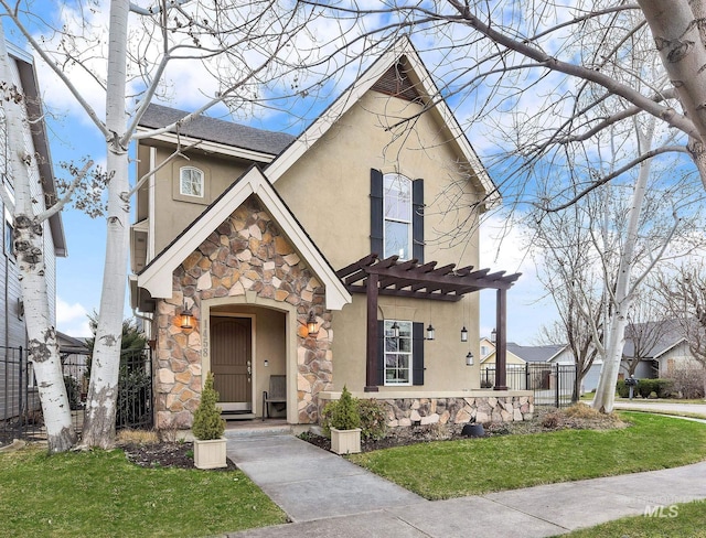 view of front of property featuring stone siding, stucco siding, fence, a pergola, and a front yard