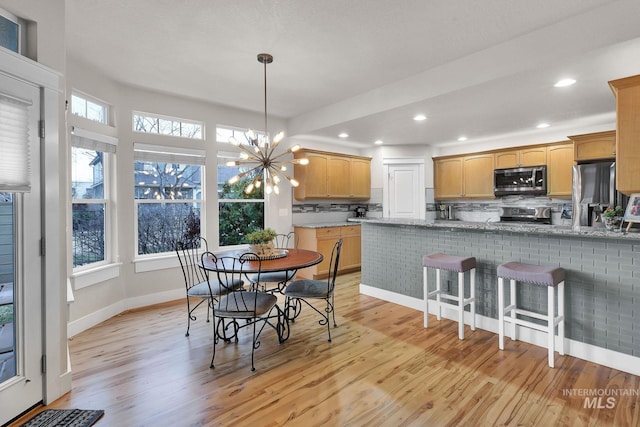 dining space featuring a chandelier, recessed lighting, light wood-style flooring, and baseboards